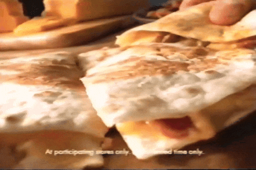 a close up of a quesadilla that says " as participating stores only " on it