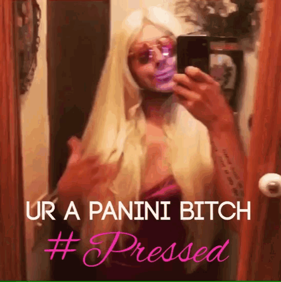 a woman taking a selfie in front of a mirror with the caption ur a panini bitch #pressed