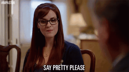 a woman wearing glasses is sitting at a table talking to a man .