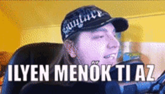 a man wearing a hat with the words " ilyen menok ti az " written on it