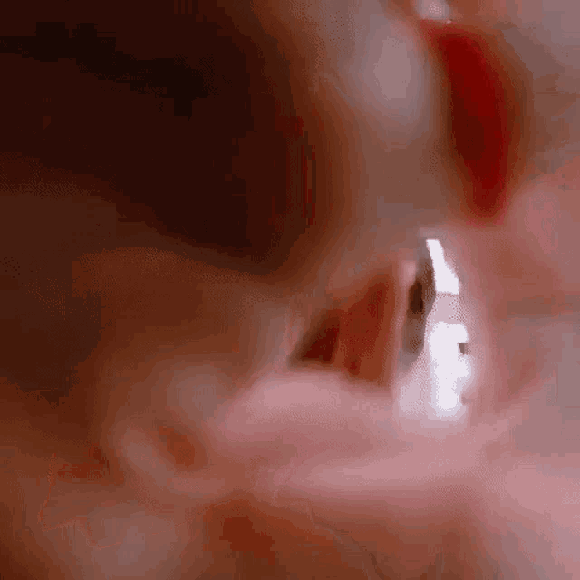 a close up of a person 's mouth with a reflection of a person in the mirror .