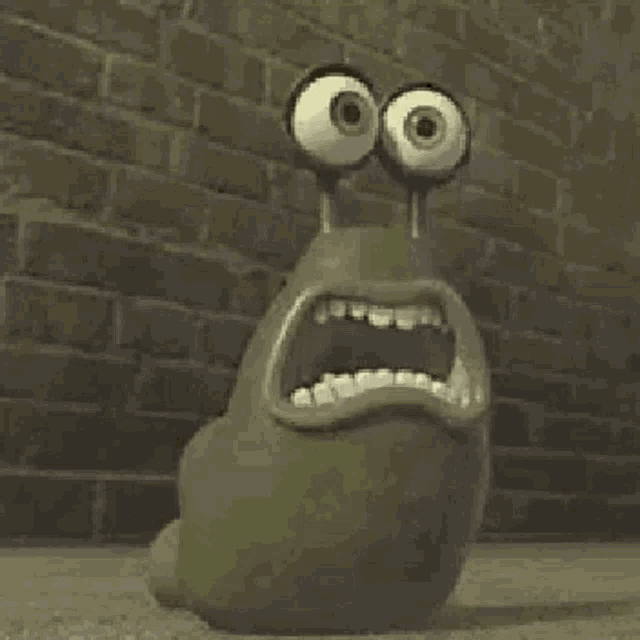 a cartoon snail with big eyes is standing in front of a brick wall with its mouth open .