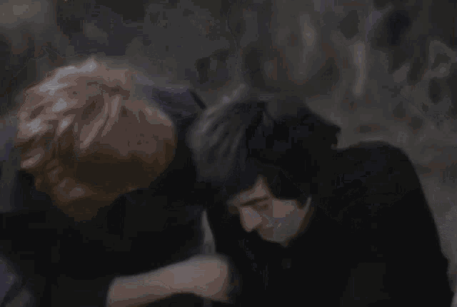 a blurry picture of a man laying on the ground with his hands on his head .