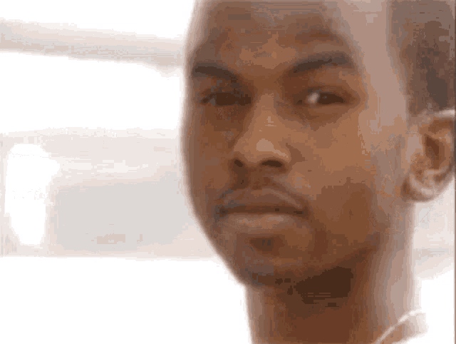 a close up of a man 's face with a serious expression .