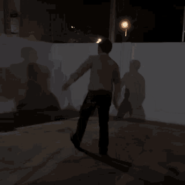 a man in a white shirt is standing in the dark