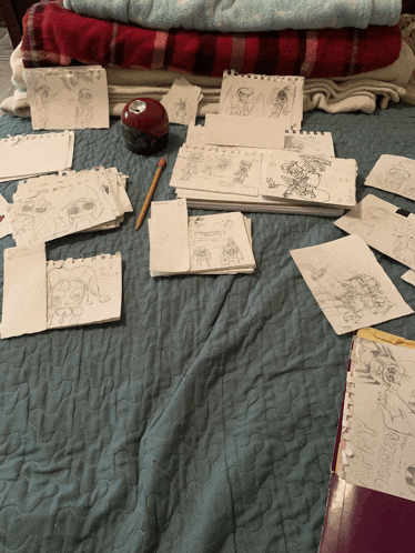 a bunch of drawings on a bed including one that says ' i love you '