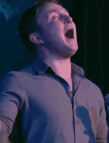 a man in a blue shirt with his mouth open