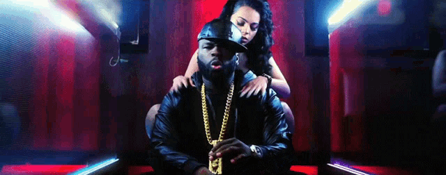 a man with a gold chain around his neck has the letter e on it