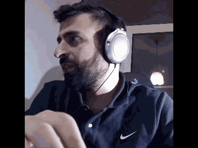 a man wearing headphones and a nike shirt looks at something