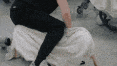 a person is kneeling on a white blanket with a stroller in the background