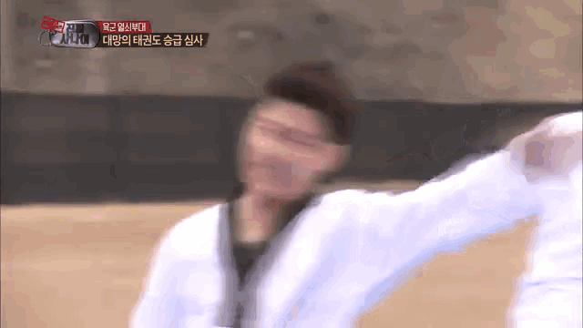 a blurry picture of a man in a white kimono with korean writing on the bottom