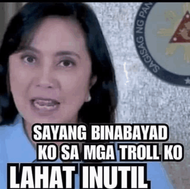 a woman is standing in front of a sign that says `` sayang binabayard ko sa mga troll ko lahat inutil ''