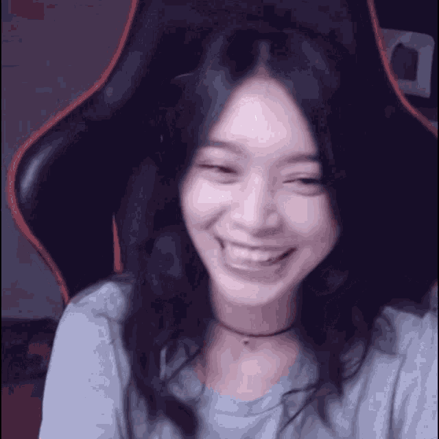 a woman is smiling and sitting in a chair