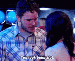 a man and a woman are standing next to each other and the man is saying " you look beautiful "