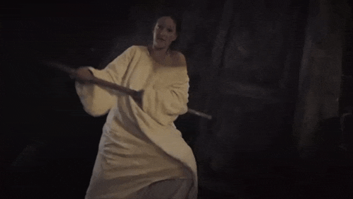 a woman in a white dress is holding a sword and the words " et bim la legende " are on the bottom