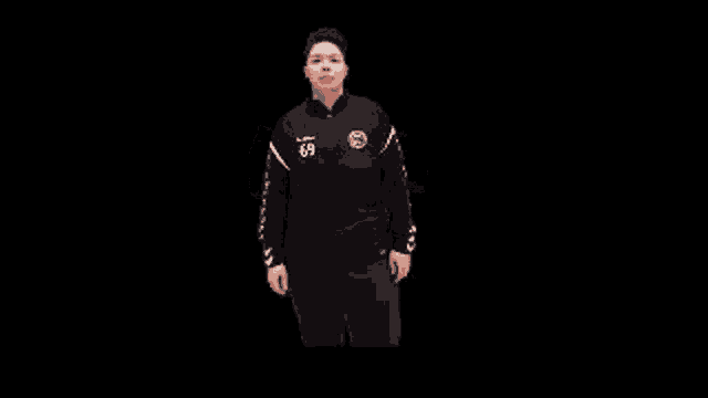 a woman wearing a black sweatshirt with the number 49 on it is dancing on a black background .