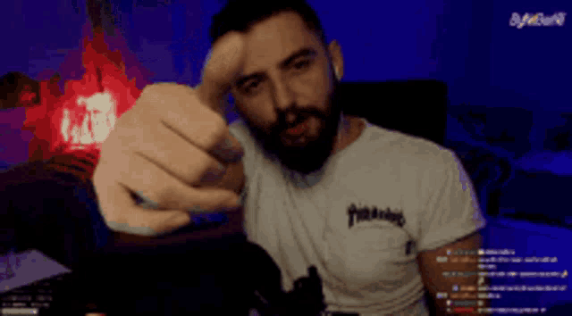 a man with a beard wearing a white thrasher shirt