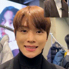 a close up of a young man 's face with a turtleneck and a suit .