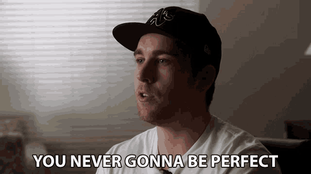 a man wearing a hat and a white shirt says you never gonna be perfect
