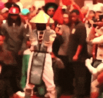 a group of people dressed in costumes are dancing in a crowd .