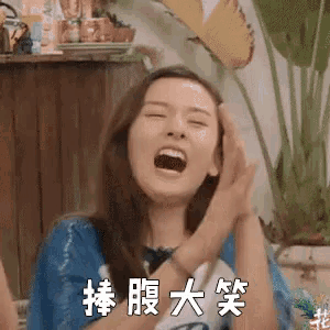 a woman is laughing with her mouth open in a room with chinese writing on the wall .