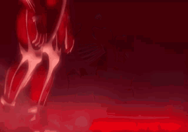 a person is standing in a dark room with a red light behind them .