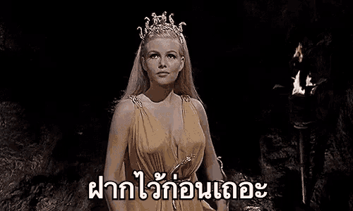 a woman in a yellow dress and tiara is sitting on a throne in a cave .