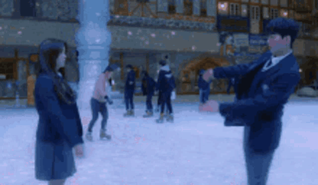 a man and a woman are standing on a ice rink looking at each other