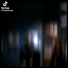 a tik tok video of a person standing in a dark room .
