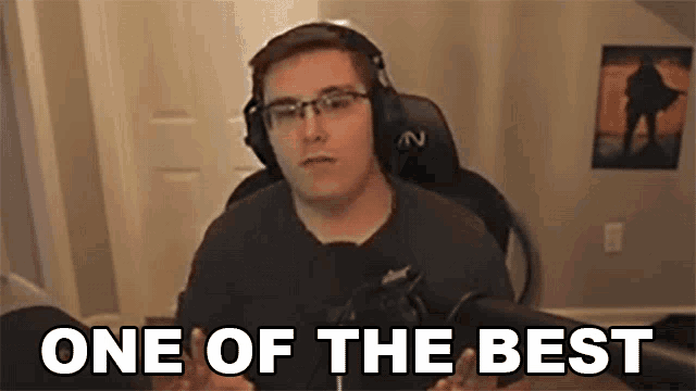 a man wearing glasses and headphones is sitting in front of a microphone and says `` one of the best '' .
