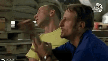 a man in a yellow shirt is talking to another man