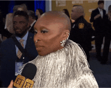 a woman with a shaved head is being interviewed with a microphone that says netflix on it