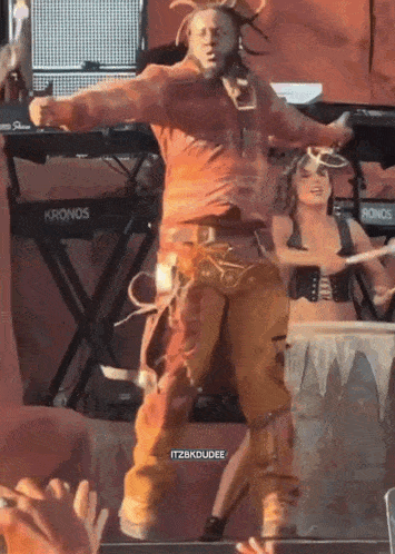 a man is dancing on stage in front of a kronos keyboard
