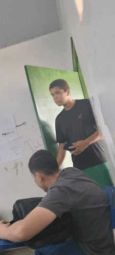 a man in a black shirt is standing next to another man in a black shirt