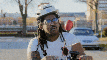 a man with dreadlocks wearing a helmet and glasses