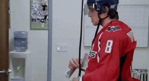 a hockey player in a red jersey with the number 8 on it