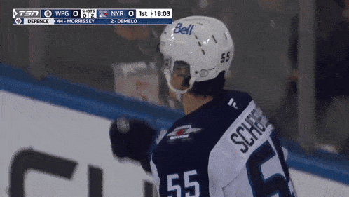 a hockey player wearing a number 55 jersey stands on the ice