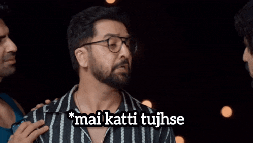 a man with glasses and a beard talks to another man with the words mai katti tujhse above him