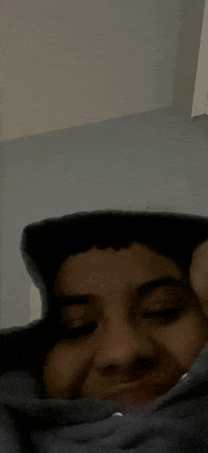 a man in a hoodie is making a funny face .