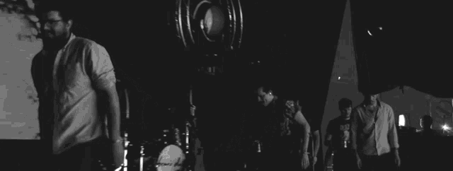 a man singing into a microphone in front of a screen that says oscar 's den