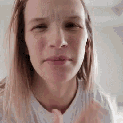 a woman in a white t-shirt is making a funny face .