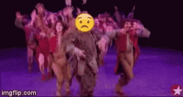 a group of people are dancing on a stage and one of them has a sad face on his head .