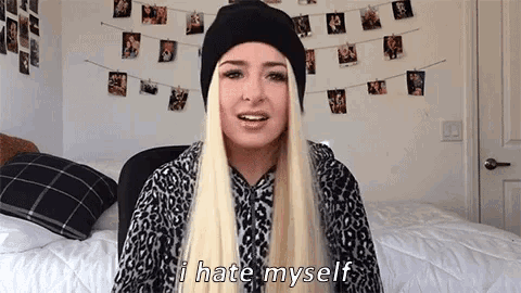 a blonde woman wearing a black hat and leopard print shirt says i hate myself
