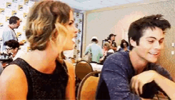 a man and a woman are sitting next to each other in a room and smiling .