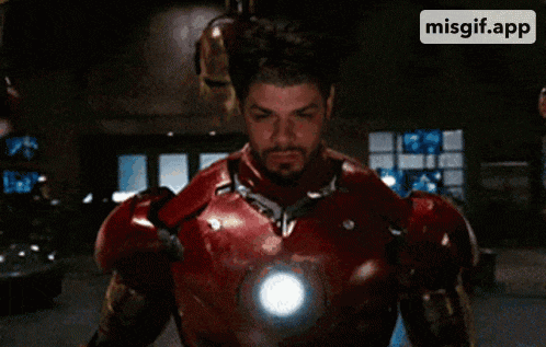 a man with a beard is wearing a iron man suit and helmet