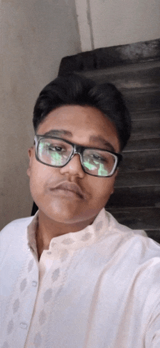 a young man wearing glasses and a white shirt