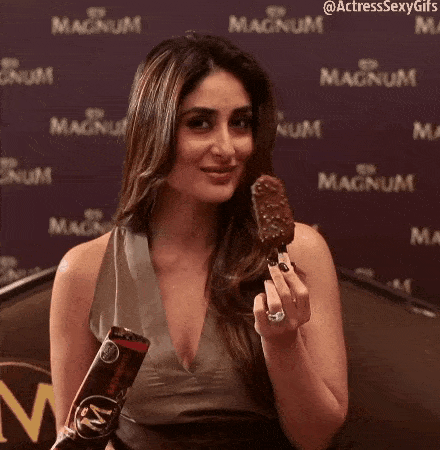a woman is eating a magnum ice cream bar .