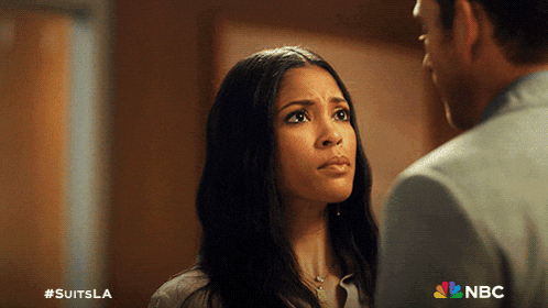 a man and a woman are looking at each other with a nbc logo behind them