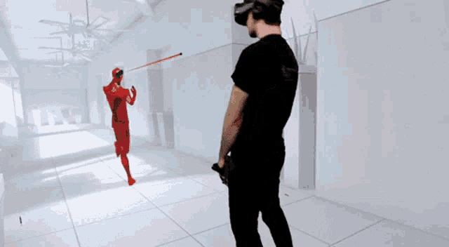 a man wearing a virtual reality headset looks at a red figure