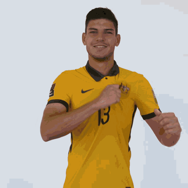 a man wearing a yellow jersey with the number 13